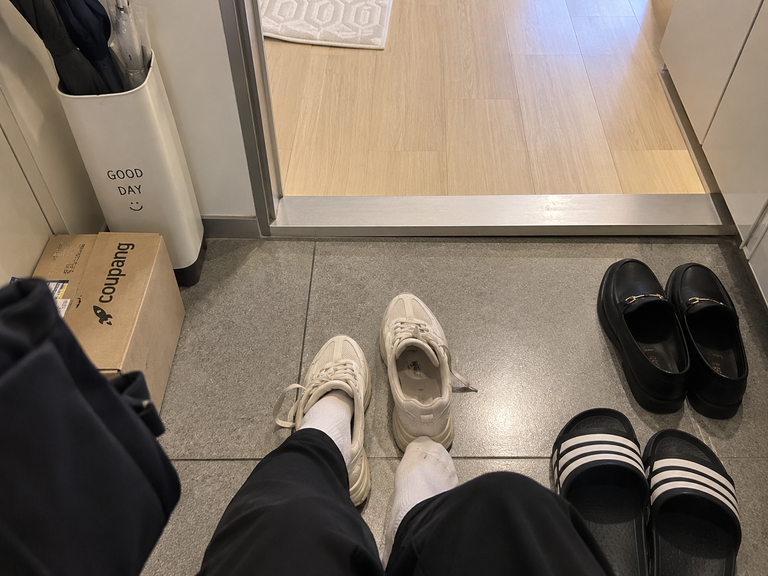 Taking off outdoor shoes at the entrance of a Korean home